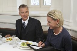 Two business partners having a discussion over a meal