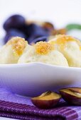 Potato dumplings with plums and buttered crumbs