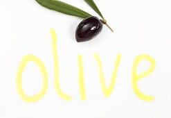 An olive and the word 'olive' written in olive oil