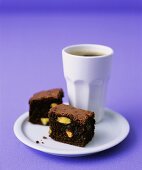 Pistachio brownies with a beaker of coffee