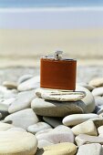 Hip flask on pebbles on beach