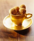 Chocolate chestnut truffles in gold cup and saucer