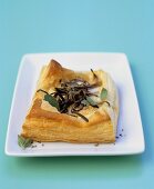 Goat's cheese and onion puff pastry tart with oregano