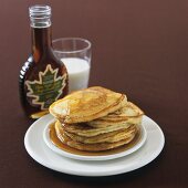 Pancakes mit Ahornsirup und einem Glas Milch