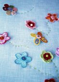 Pale blue fabric decorated with embroidery and fabric flowers