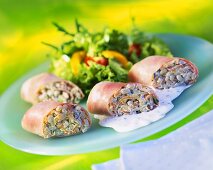 Ham rolls with barley and vegetable filling and salad leaves