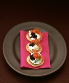 Small blinis topped with creamed horseradish, smoked salmon and caviar