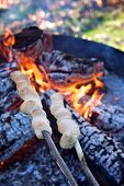 Stockbrot über Flamme haltend