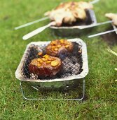 Two steaks with mango marinade on small barbecue out of doors