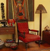 Roter Sessel zwischen afrikanische Skulpturen und Mitbringsel