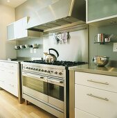 Küche mit großem Gasherd und modernen Küchenschränken mit Edelstahlflächen