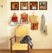 Eine Gemäldeserie und verschiedene Taschen über einem antiken Stuhl
