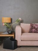 Couch and table lamp against grey wall