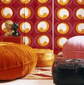 Various floor cushions in front of colourful wallpaper