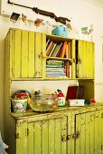 Grüner Vintagebuffetschrank mit Büchern und Goldfischglas