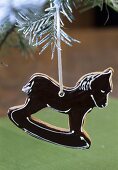 Rocking horse tree ornament hanging on a fir branch