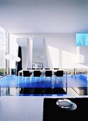 Moderner Wohnraum mit länglichem Esstisch und verschiedenen Glas- & Spiegelflächen