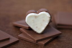 Heart-shaped chocolate pralines on squares of chocolate