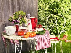 Gartentisch mit Milchprodukten, Tomaten und Frühlingszwiebeln