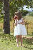 A little girl biting into an apple