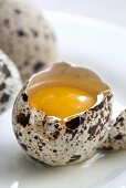 A cracked open quails' egg