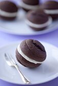 A chocolate whoopie pie on a plate (close-up)