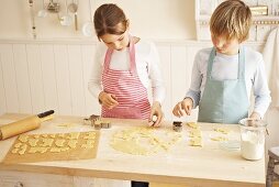 Children cutting out biscuits