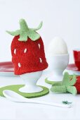 A strawberry-shaped egg cosy
