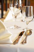 Fabric napkins, silver cutlery and glasses on tablecloth