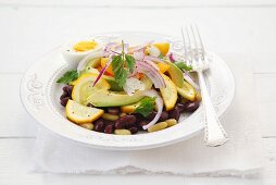 Bean salad with courgettes, tomatoes, avocado, onion and egg