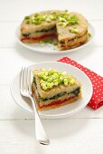 Potato cake with layers of spinach & peppers, spring onions