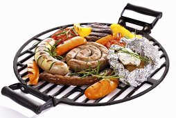 Sausages and vegetables on barbecue rack