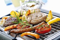 Meat, sausages and vegetables on grill