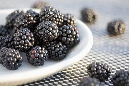 Blackberries on and beside a plate