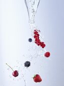 Water and berries pouring out of bottle
