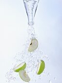 Water and apple slices pouring out of bottle