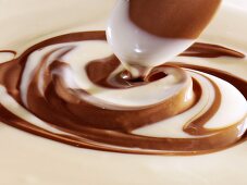 Mixing white and dark chocolate sauce with wooden spoon