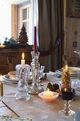 Weihnachtlich gedeckter Tisch mit Kerzen und Rotweinglas