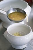 Ladling French onion soup into a bowl