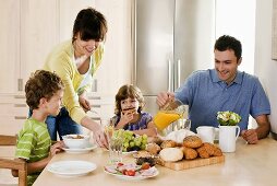 Junge Familie mit zwei Kindern beim Frühstück