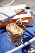 Banana and vanilla cream in glass in front of books