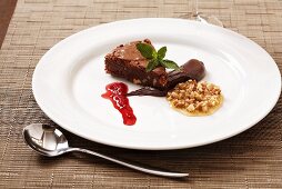 Chocolate nut cake with raspberry sauce and nuts