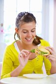 Girl eating cheese and salad sandwich