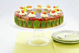 Cake with grape jelly, mint leaves and cream rosettes