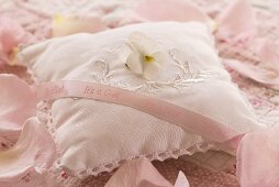 Rose-scented pillow with horned violet and pink ribbon