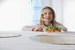 Girl holding vegetables on a fork