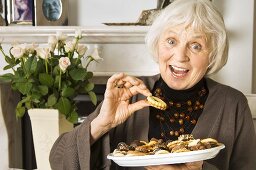 Elderly lady eating biscuits