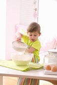 Girl sieving flour into a bowl