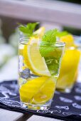 Mineral water with lemon wedges and mint leaves