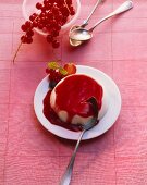 Panna cotta with fruits of the forest sauce and redcurrants